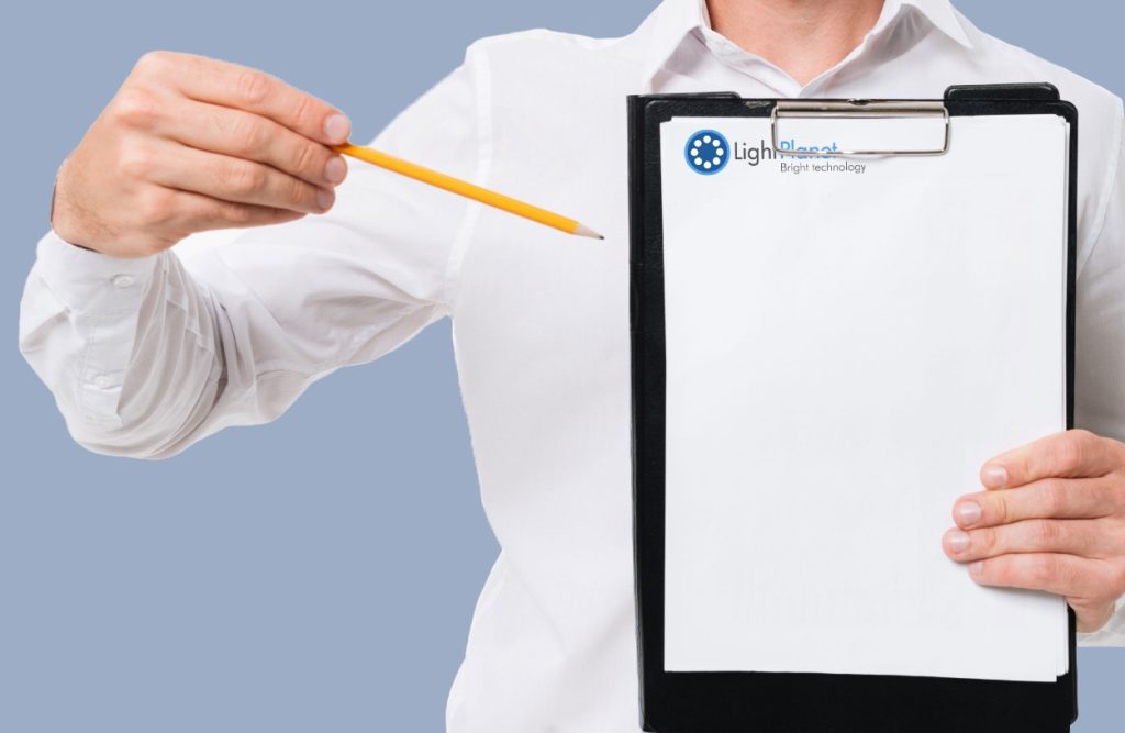 man holding clipboard with Light Planet logo and pointing pencil